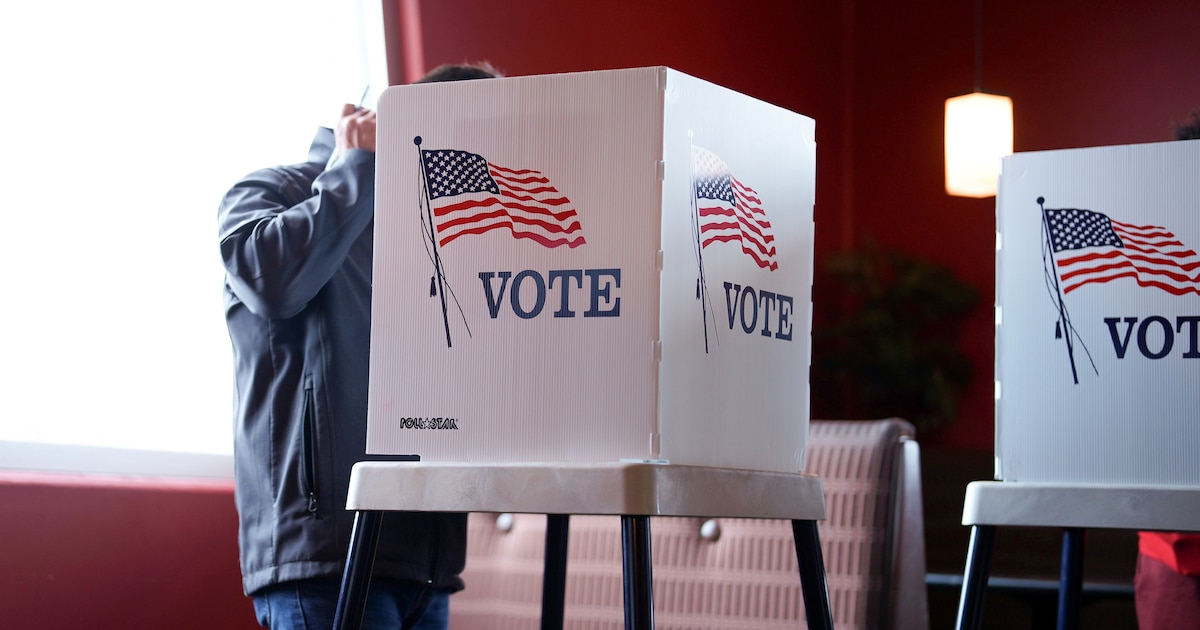 Cómo votar el 3 de noviembre: votante en cabina con la boleta electoral